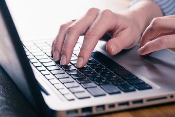 Woman working at home office hand on keyboard close up