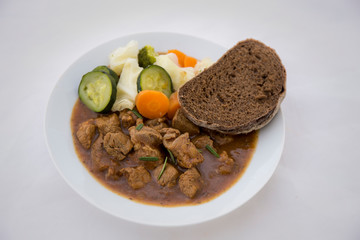 beef casserole in the bowl with steamed vegetable