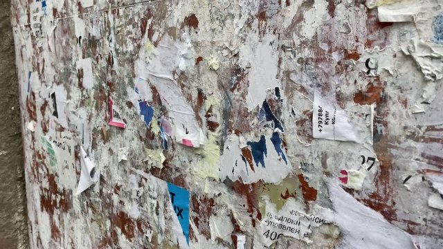 Wall full of ripped paper ads.