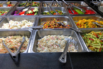 Deli food trays stacked and steaming with a variety of healthy foods for lunch and dinner menu. Traditional New York style deli food.