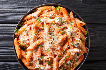 Penne Alla Vodka is thick and hearty pasta dish with a delicious creamy vodka tomato sauce close-up in a plate. Horizontal top view