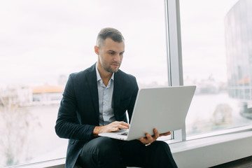 Office work, business situation. A young business man with a laptop in his hands.