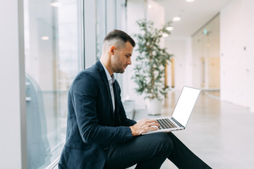 Office work, business situation. A young business man with a laptop in his hands.