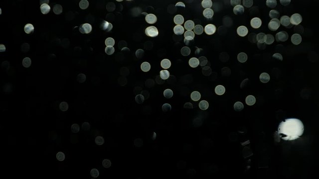 Abstract background with light bokeh on a dark window, dark rainy night concept 