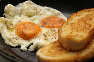 breakfast of fried bread and fried egg with pepper ground