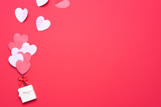 Valentine's day background with red and pink hearts like balloons on pink background, flat lay