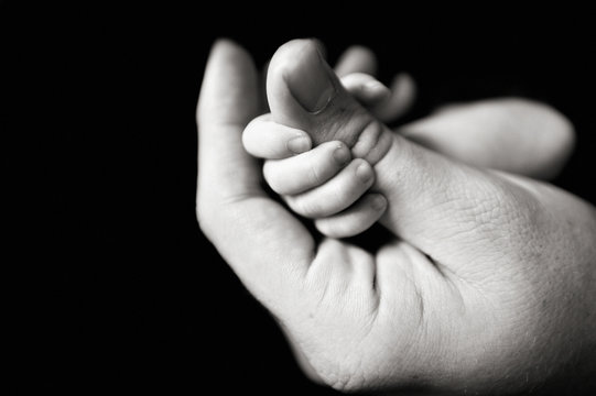 newborn baby holding fathers hand