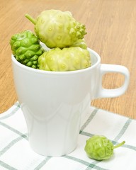 Green Noni or Morinda Citrifolia Fruits in White Cup