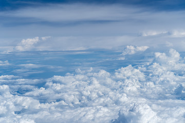 The plane's wings fly above the clouds, the sky view from the plane's window at thirty thousand feet above the water level. With air transportation for traveling