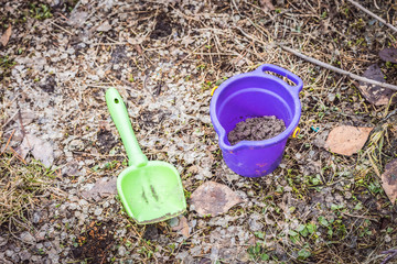 Childrens toys bucket with shovel for games and entertainment for children on grass.