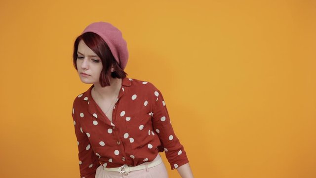Gorgeous pretty young lady with red hat wearing red shirt with white polca dot trying to hear both hands on ear gesture, curious for gossip. Hearing problem, deaf