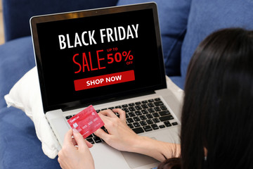 Woman hands holding credit card and using laptop computer for shopping black friday online sale, e...