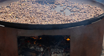 Cooking a large amount of chestnuts on a brazier. Fall season. Chestnut Festival