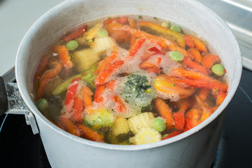 Vegetable mix cooked in small saucepan on stove.