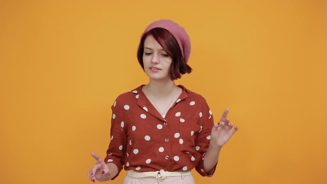 Young beautiful brunette woman wearing red shirt with white polca dot over isolated yellow background smiling and laughing doing rock symbol with hands up. Music star. Funny concept.