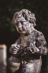 statue of boy playing instrument in garden