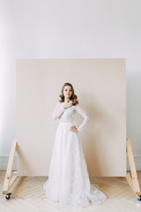 Fototapeta premium European wedding in the style of fine art. Modern bride in white interior Studio.