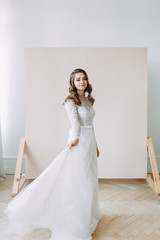 Fototapeta premium European wedding in the style of fine art. Modern bride in white interior Studio.