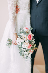 Floristry of eucalyptus and Ranunculus in the hands. The bride's bouquet in the bright Studio.