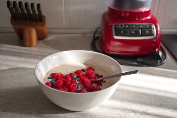Closeup of oat flakes with berry fruit on the desk in the kitchen