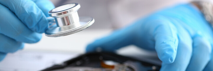 A male repairman wearing blue gloves