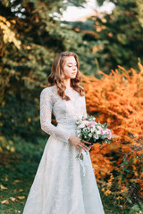 Obraz na płótnie Canvas Autumn wedding in European style. Beautiful bride in white dress in the Park.