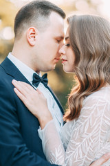 Autumn wedding in European style. Beautiful couple in suit and white dress in Park.