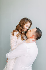 Stylish wedding in European style. Beautiful couple celebrating and drinking champagne in the Studio.