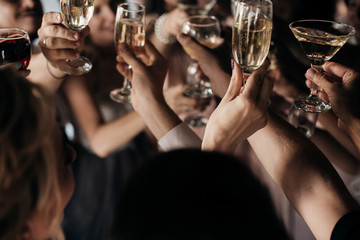 people celebrate and clink glasses. Hands with glasses