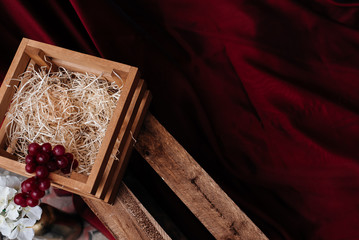 wooden box with grapes on a red background