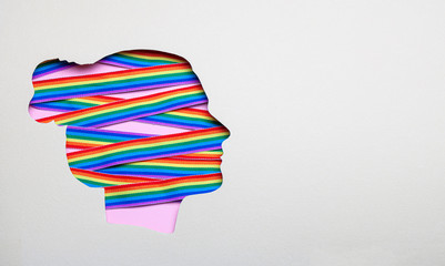 Silhouette of a female head and rainbow ribbons of LGBT pride. Lesbians in the head. Copy space for text.