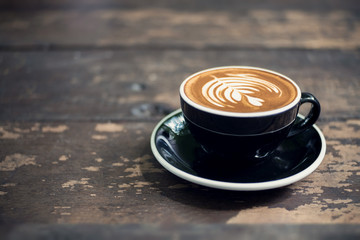 Latte art, coffee latte cup on a wood table.