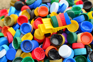 Dump truck unloads colorful plastic caps.  Concept for the collection, recycling of plastic bottle caps