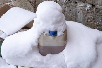 canister of liquid on snow. liquid in frost during day. snowdrift