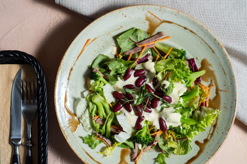 Mixed green salad with vegetables and nuts. vegan salad with beans. Natural nutrition. Fresh vegetables. Healthy eating concept