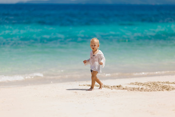 Fototapeta na wymiar Baby boy blond plays on the ocean