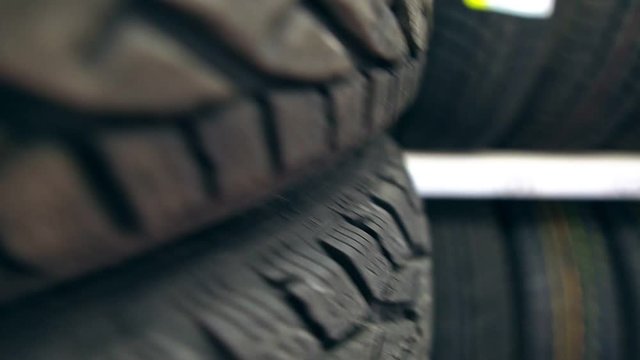 Many new winter tires on shelves and in columns. Panorama of the store