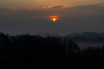 Fototapeta premium The sun behind the cloud. Cloudy dawn in the fall.