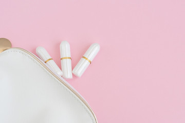 tampons and cosmetic bag on pink background. woman period concept.