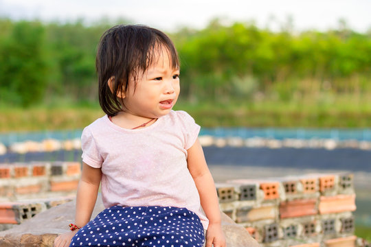 Portrait image of 1 years and 4 months old baby girl. Asian child girl crying when she playing with the toy at the playground. Expression and emotions of baby concept.