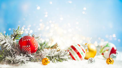 Christmas winter background with gift box, Christmas baubles and fir tree branches on snow.