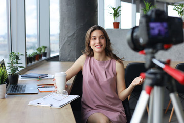 Beautiful young woman talking and smiling while making new video for her blog.