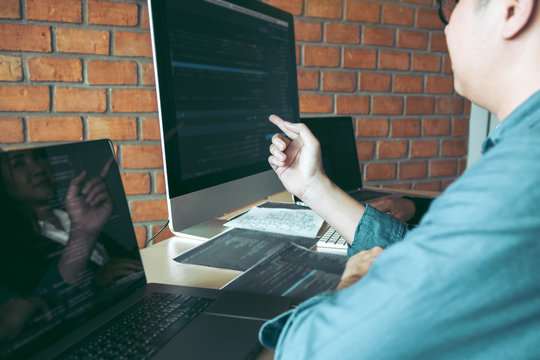 Developing programming and coding technologies working in a software engineers developing applications together in office.