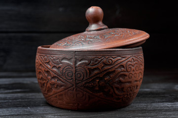 brown clay pan on a black wooden background