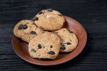 cookies on a black background with a clay plate
