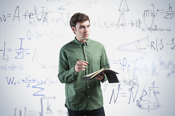 Young man with notebook, science formula