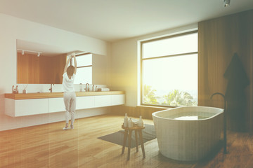 Woman in wooden and white bathroom corner