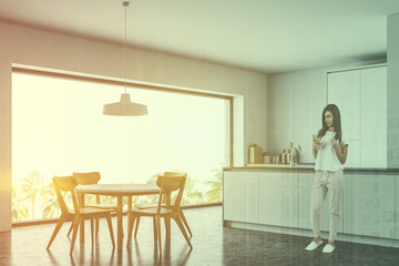 Woman in panoramic kitchen with table and counter