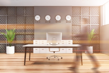 Businessman walking in gray CEO office
