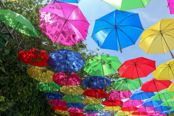 Fototapeta na wymiar Blue Pink Red Green Yellow And Colourfull Umbrella Hang Over on the top or above As Decoration or Background and Grass Angle